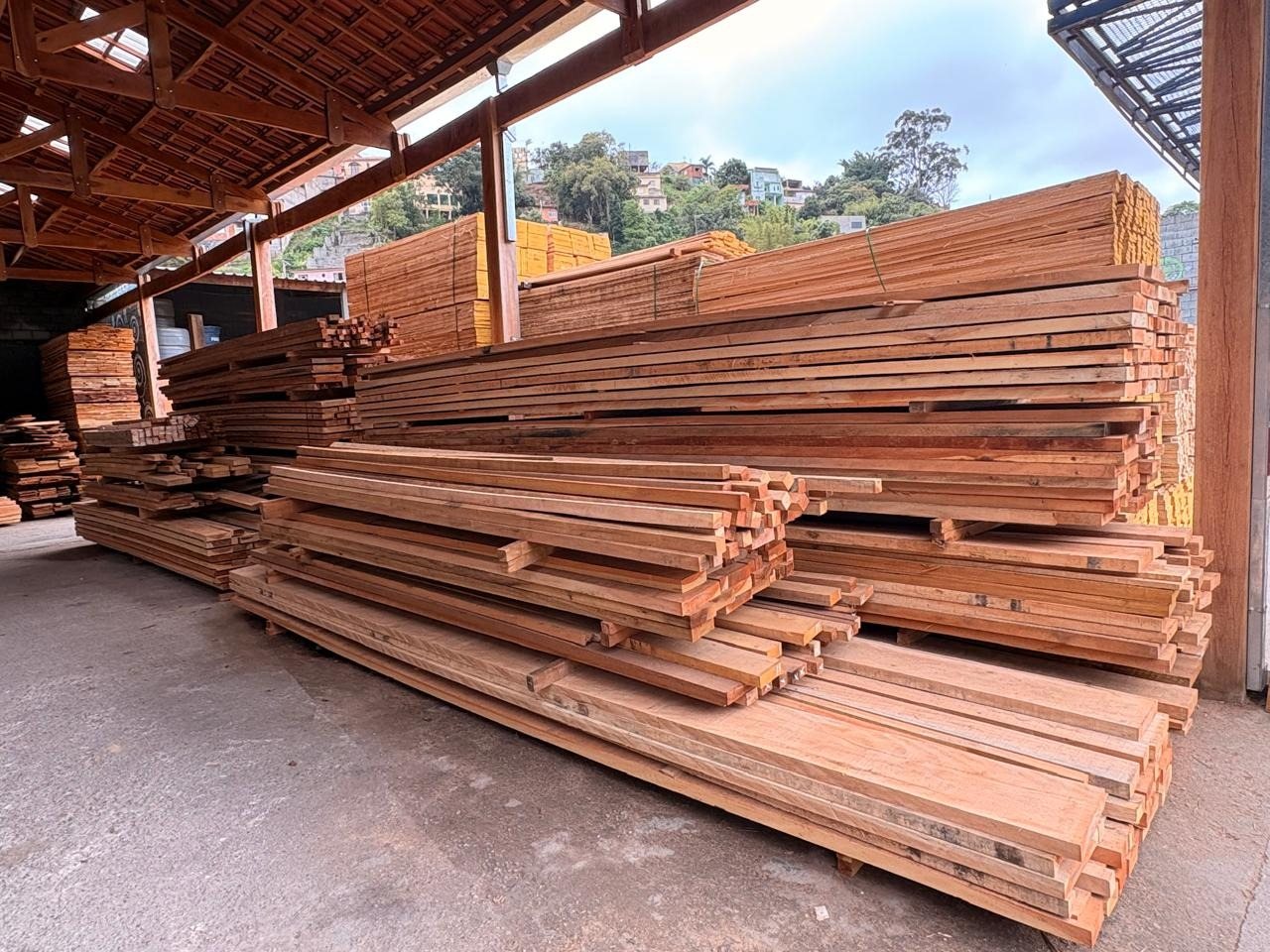 Pilhas de peças de Cambará Rosa no pátio da Rocha Telhas