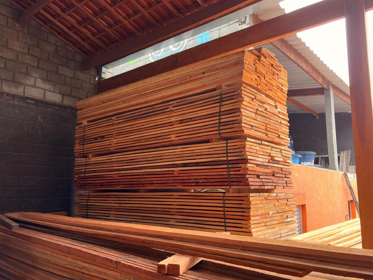 Pilha de tábuas de Cedrinho no pátio coberto da Rocha Telhas